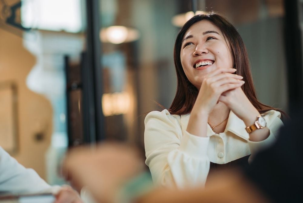 Actuary sitting at desk and smiling.
