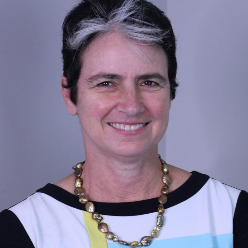 Portrait photo of Jennifer Lang in top with white and yellow colours and black trim and gold necklace