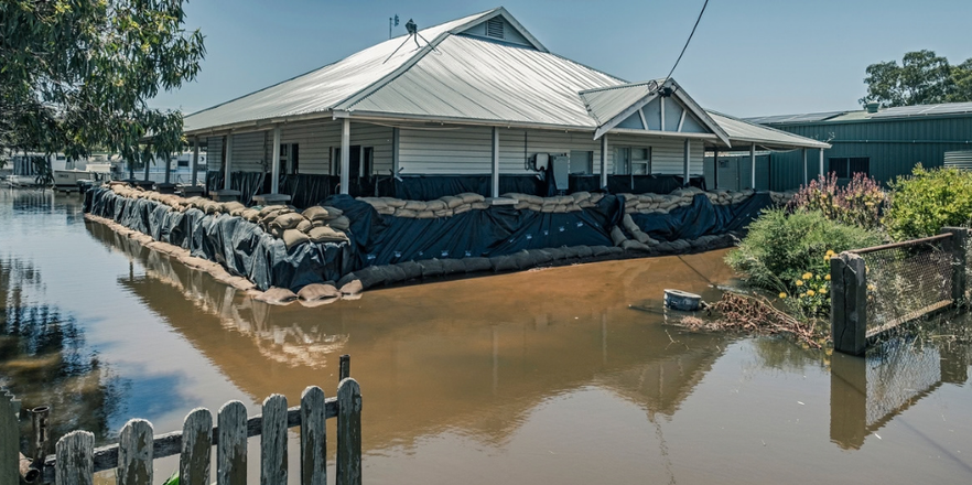 House in floodwaters with makeshift sandbags