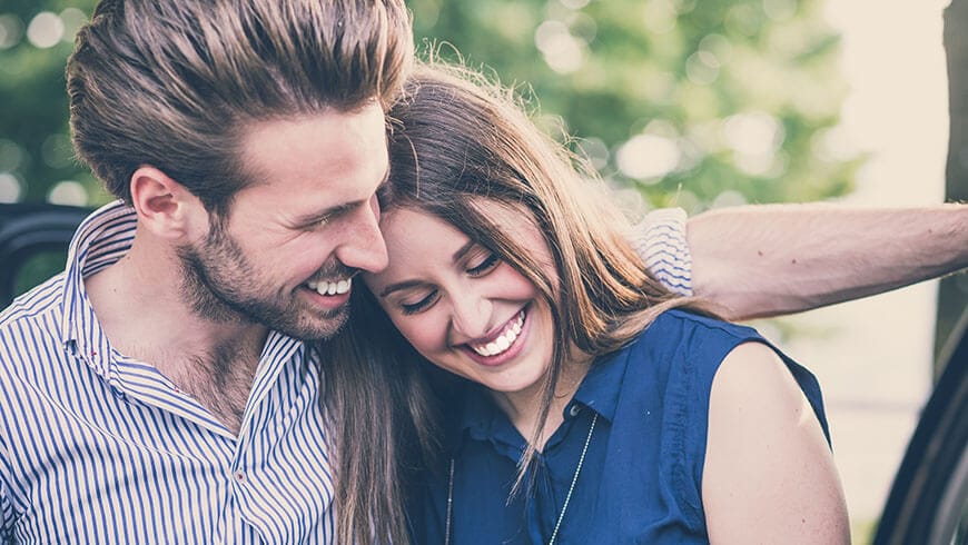 Couple smiling and hugging.