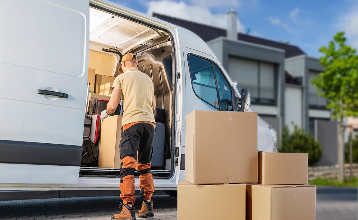 Man unloading parcels from van.