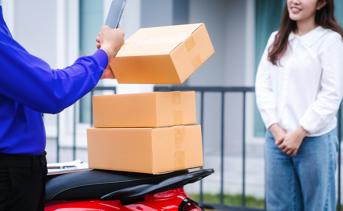 Rider taking a photo of parcels before handing it to receiver.