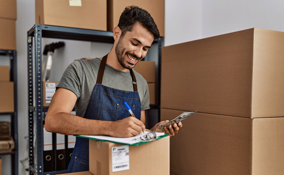 Man checking inventory on his clipboard at a warehouse.