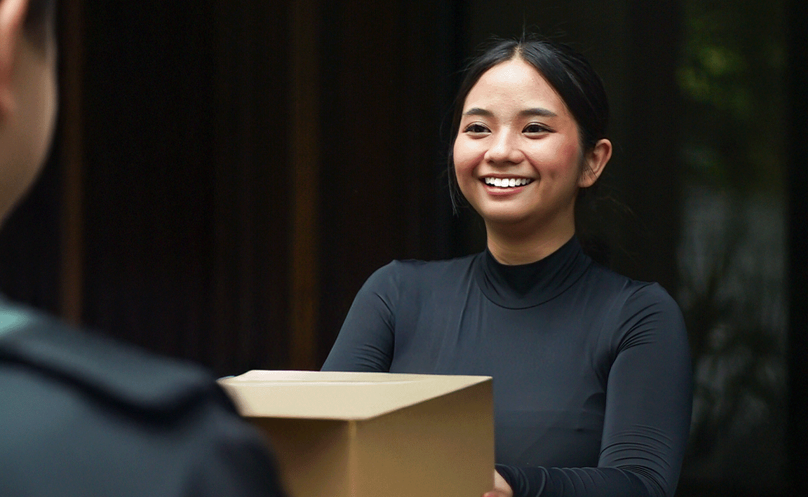 Woman smiling while receiving parcel 