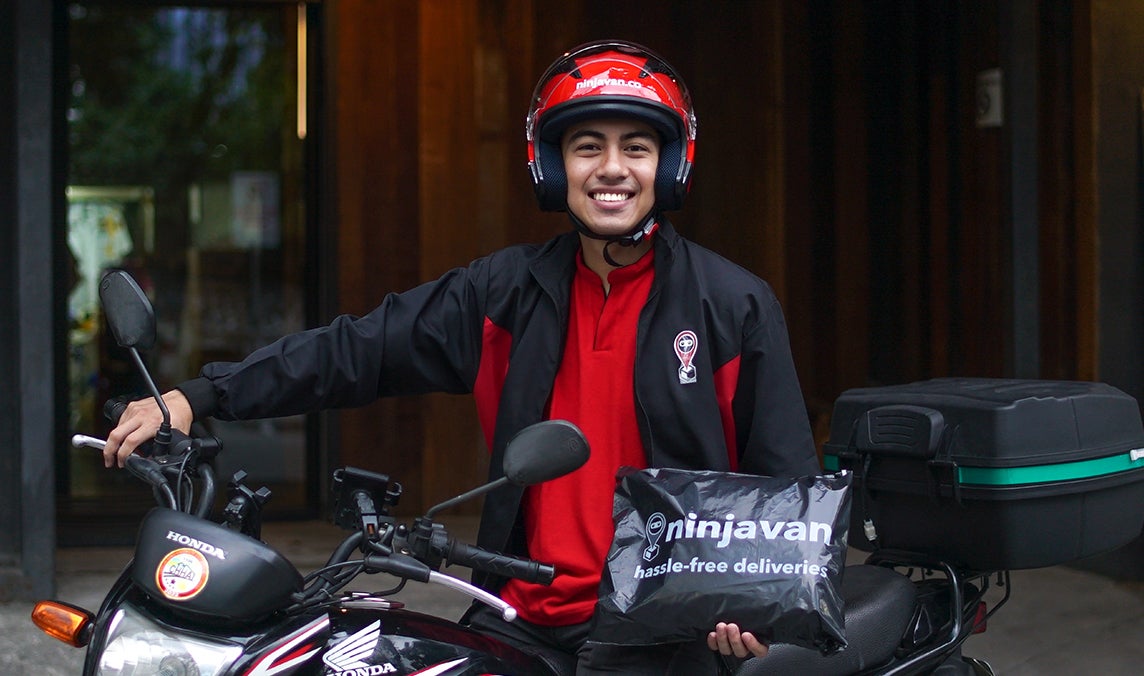 Rider smiling and holding parcel