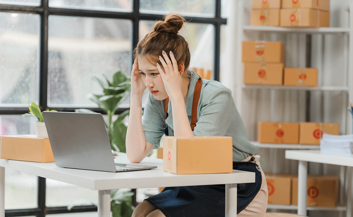 Woman stressed while looking at laptop