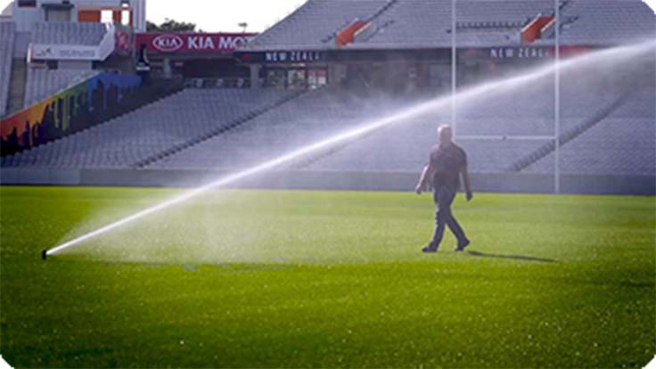 Eden Park Turf Manager walking towards sprinklers spraying water from new water bore