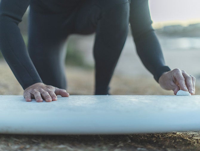 Man polishing surfboard