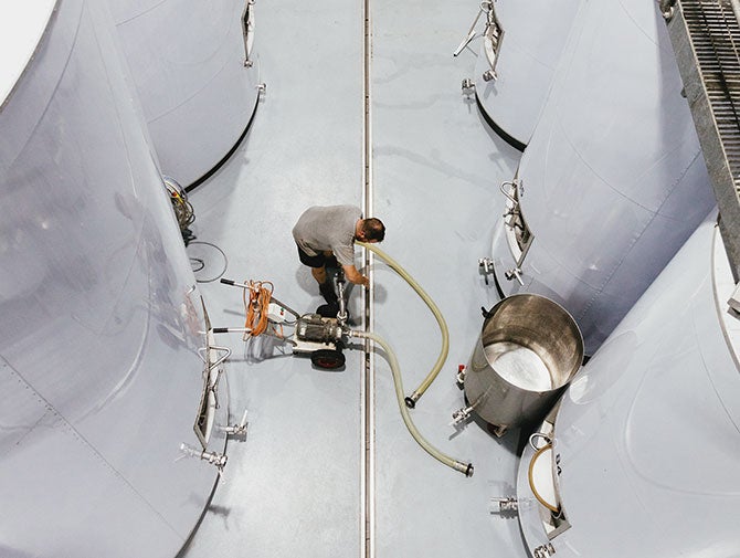 Man working with wine fermentation tanks