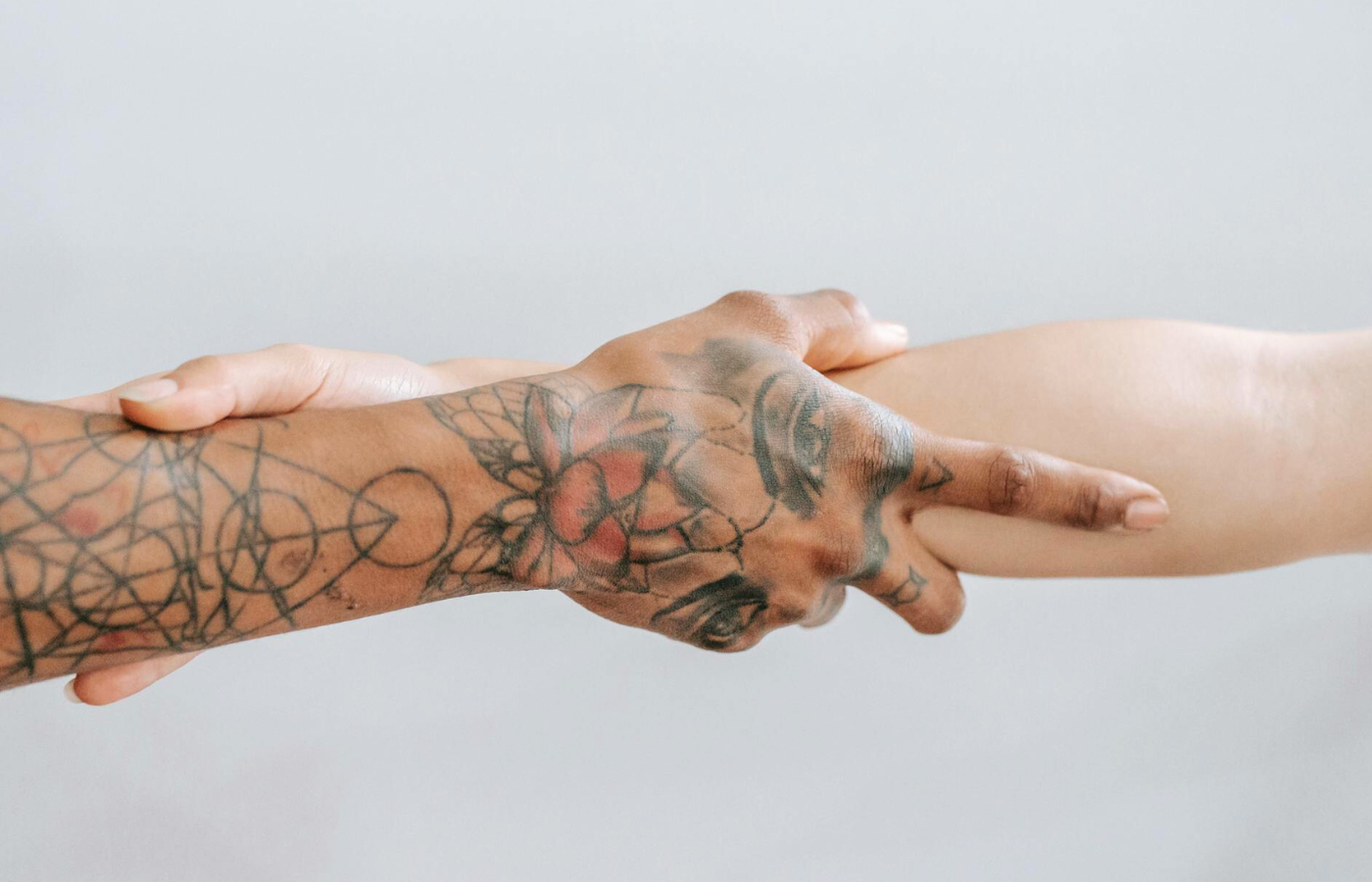 A close up of a couple's right arms. They are grasping each other in a gesture of closeness, connection and commitment. 