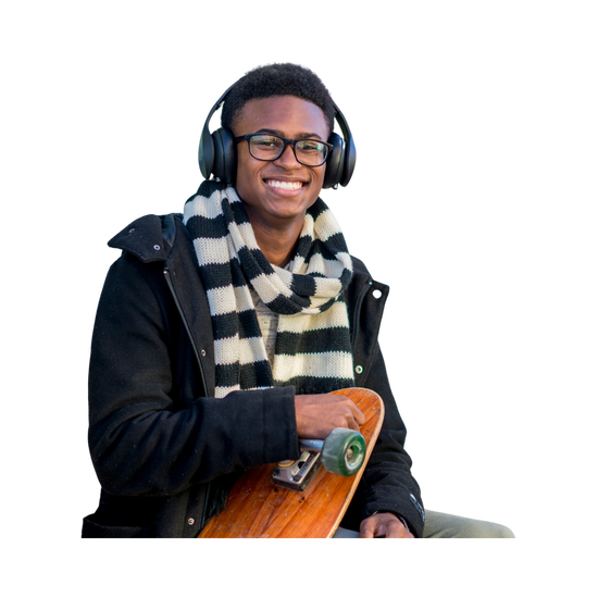 Image of young man smiling while holding a skate board and headphones on ears