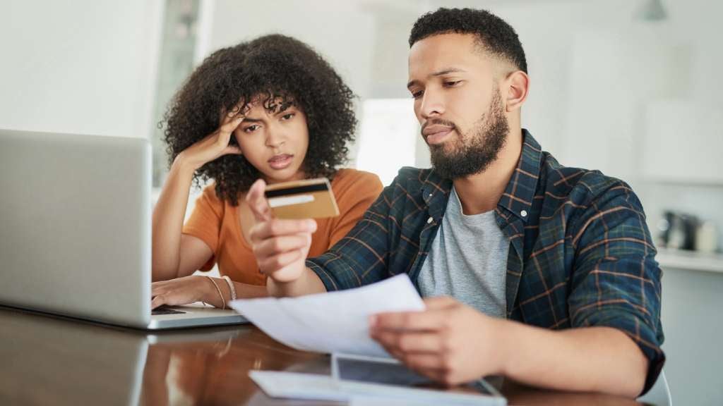 Couple looking stressed while paying credit card bill 