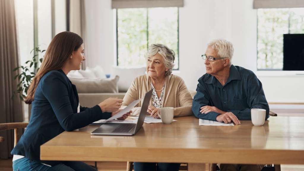 Senior man and woman meet with funeral director at home