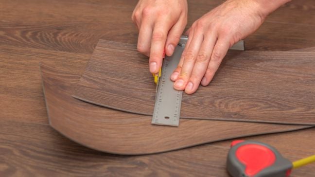 使用美工刀裁切塑膠地板。