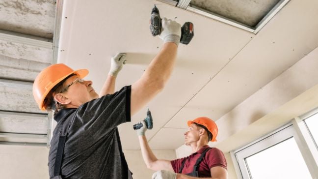 工人正在使用釘槍安裝矽酸鈣天花板
