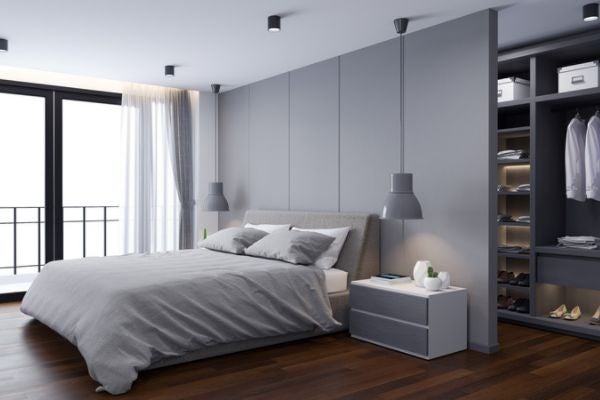 以板材做隔間，在床頭後方做出半開放式的系統換衣間