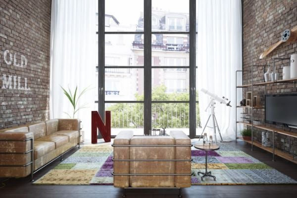 採工業風室內設計的客廳，牆面為裸露的磚牆，沙發旁有金屬水管裝飾