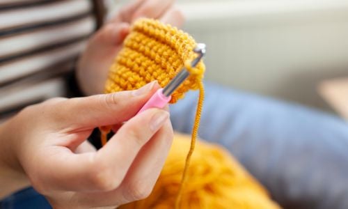 用一枝金屬鉤針進行毛線編織