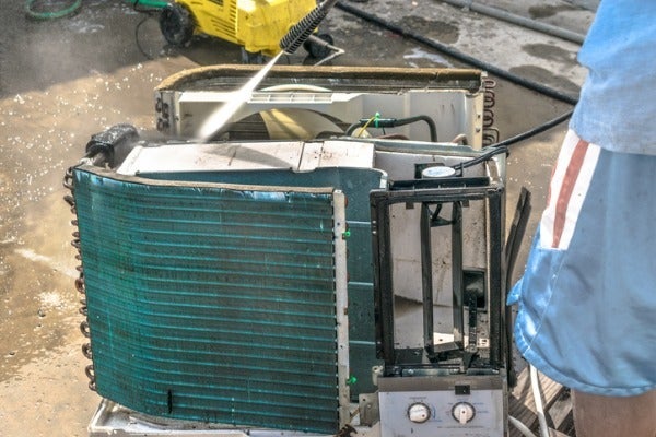 ▲師傅在清洗窗型冷氣時，會使用高壓水柱沖洗