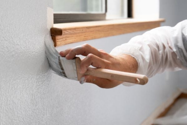 用油漆刷在牆上塗抹白色油漆