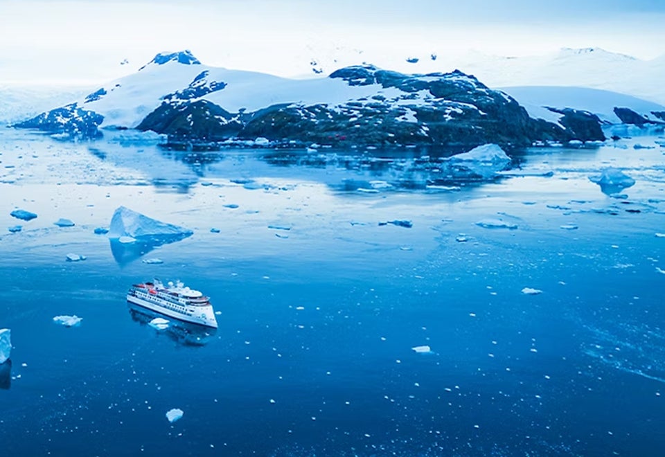 Aurora Expeditions | Aerial shot of an Aurora Expeditions ship in Arctic waters | Devotion