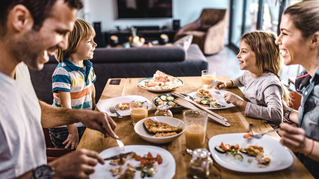 Family of four at dinner table enjoying a meal