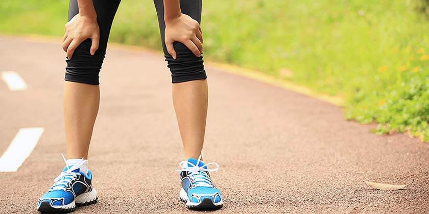 Woman in running tights as visible from knees down resting after a run