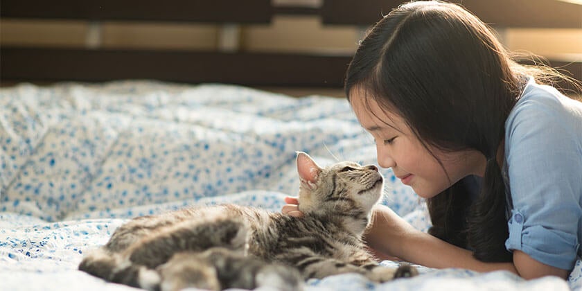 girl cuddling with cat