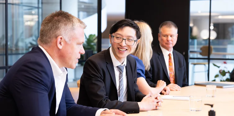 Four actuaries sitting at a boardtable having a discussion