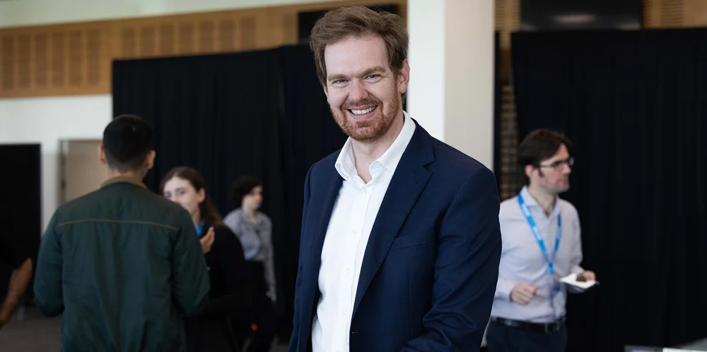 Actuary with brown hair checking in at an Actuaries Institute event