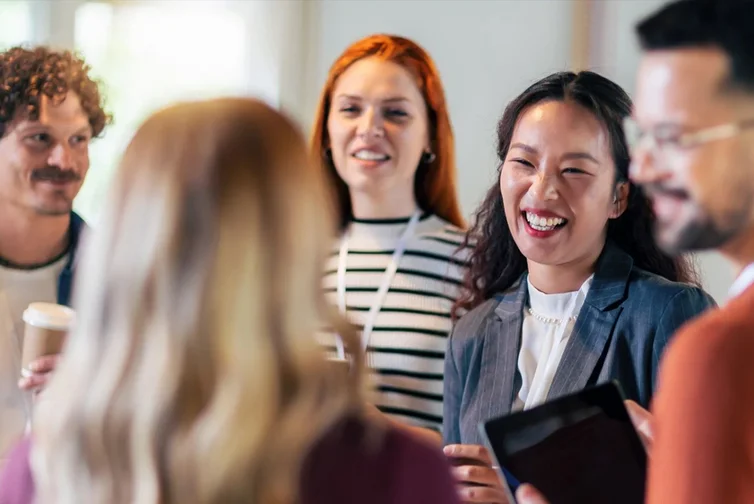 Five people at a conference talking and laughing