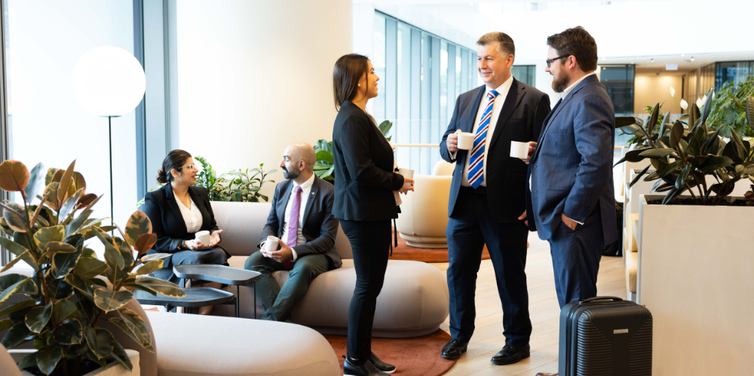 Business people standing and sitting in an office foyer chatting
