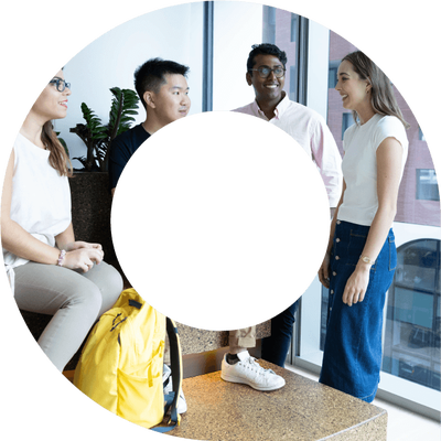 Four young actuaries standing talking to each other and networking