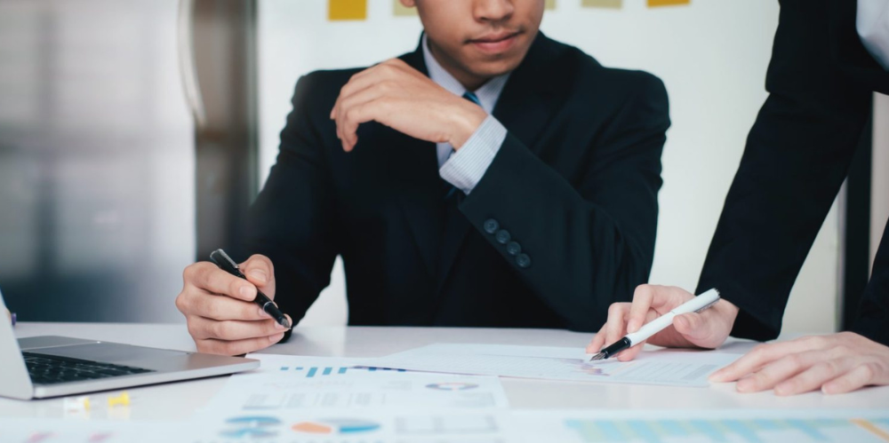 Business discussion between two people showing each other some documents