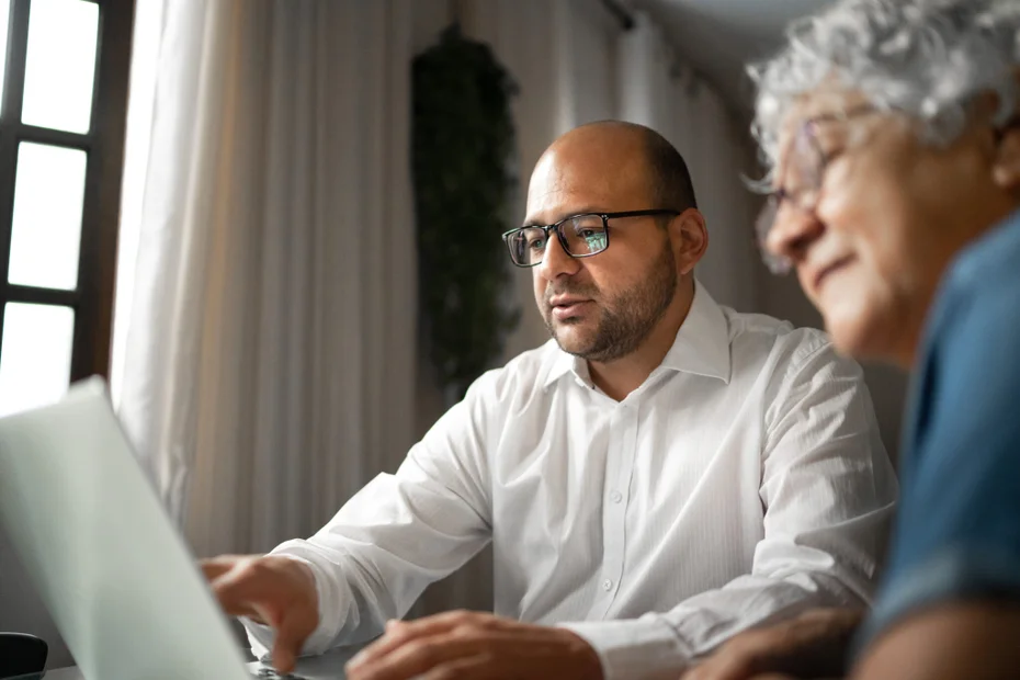 Advisor helping a senior woman at home (or mother and son)