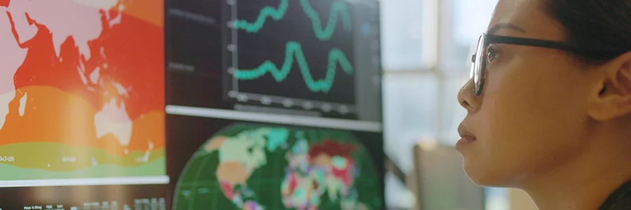 Woman in glasses looking at globe map on screen