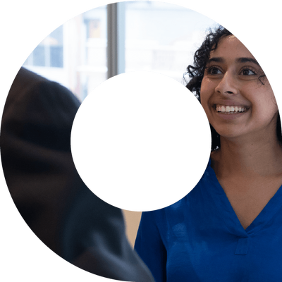 A young woman in blue shirt smiling within a viewfinder shape