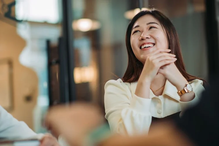 Woman sitting at desk and smiling.