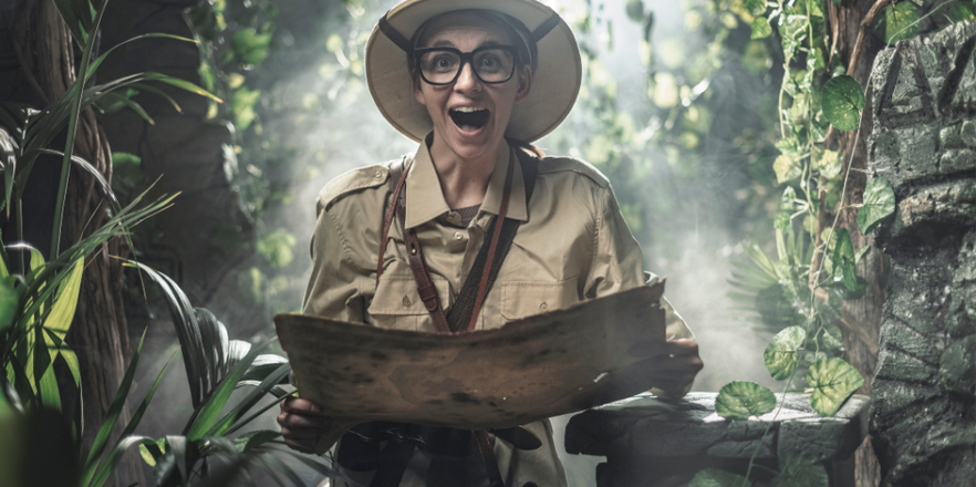 Cheerful woman exploring a tropical jungle with a map, she finds some ancient ruins.