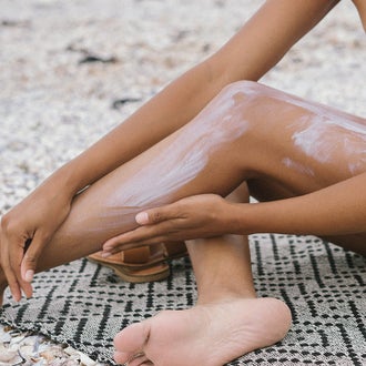 Woman putting sunscreen on legs