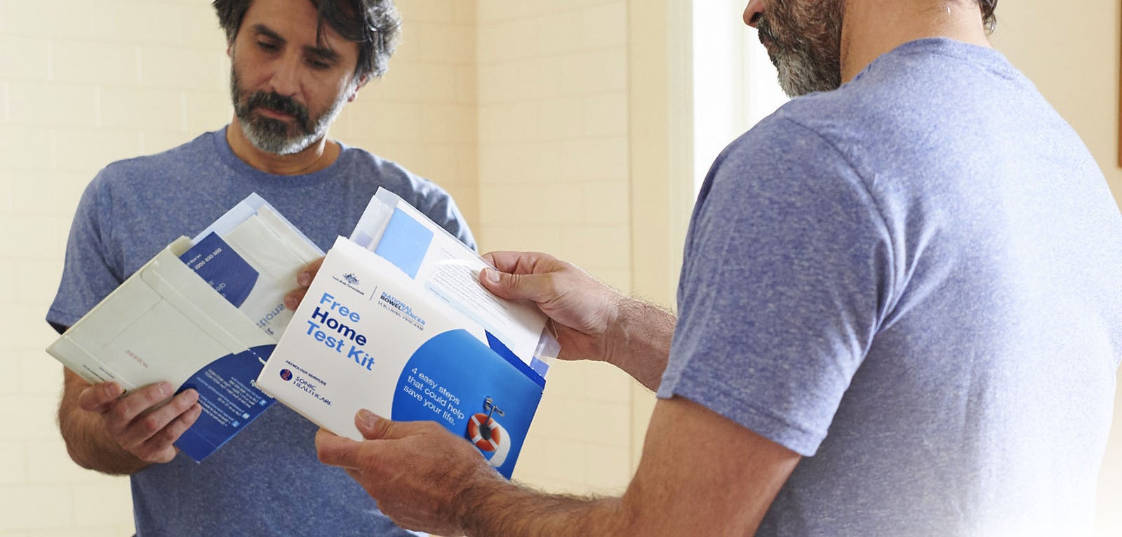Man holding Bowel Cancer test kit.
