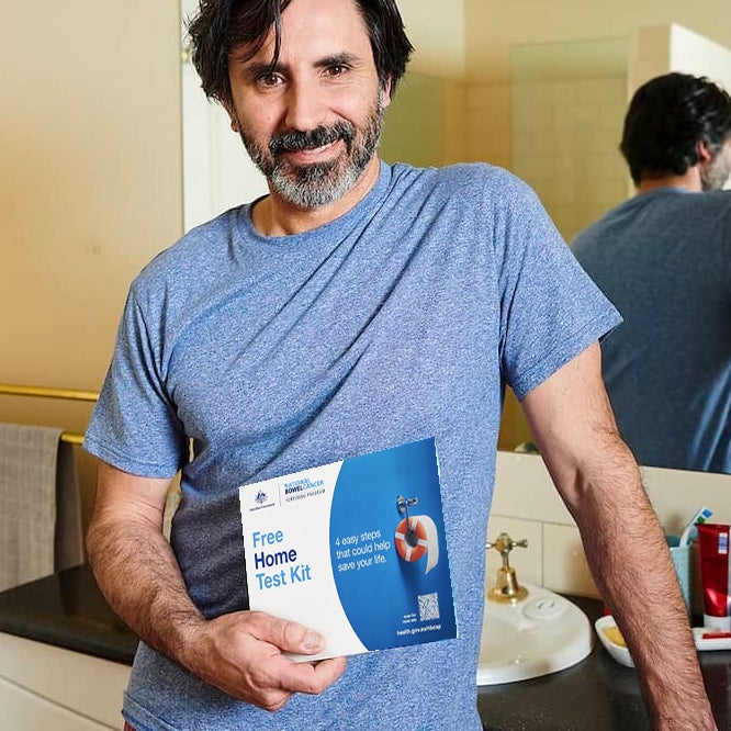 Man holding Bowel Cancer test kit.