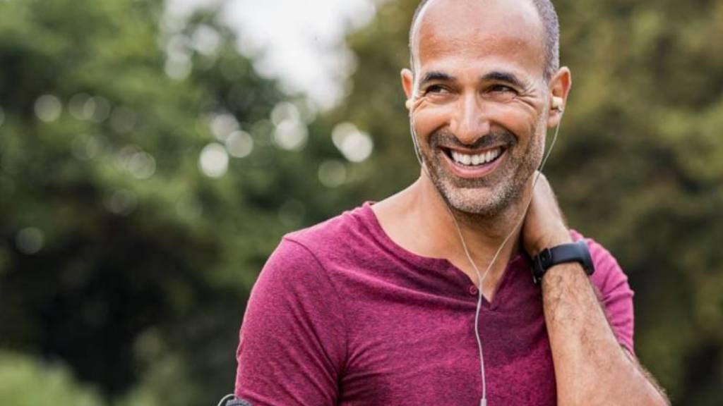 Man jogging in park smiling