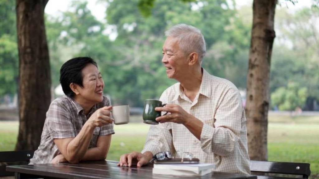 Senior couple having tea in a park together.