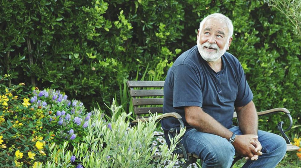 happy senior man sitting in the park on a bench.