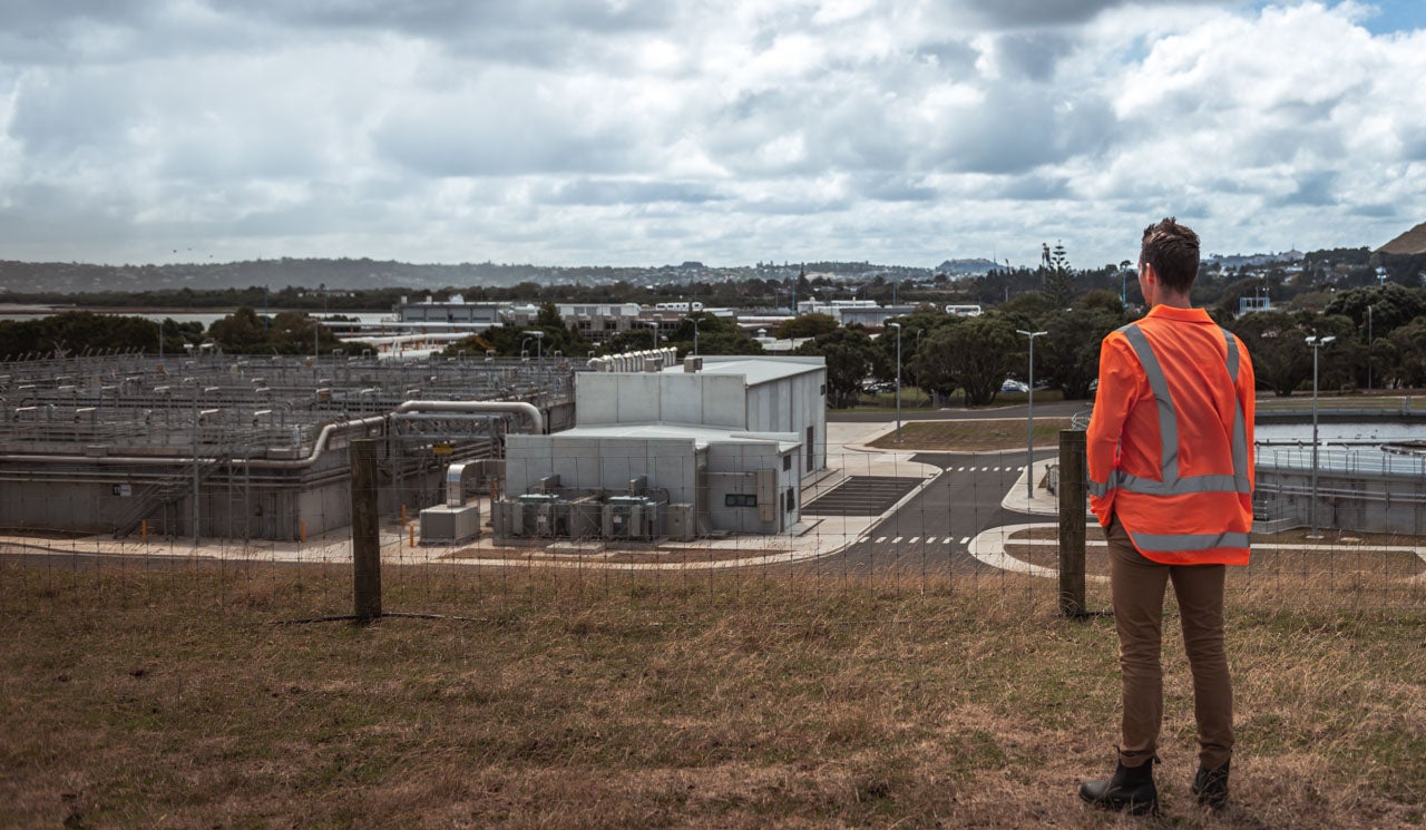 Watercare's Environmental Scientist Liam Templeton takes in a view of the large infrastructure outdoors at the Māngere Wastewater Treatment Plant. 