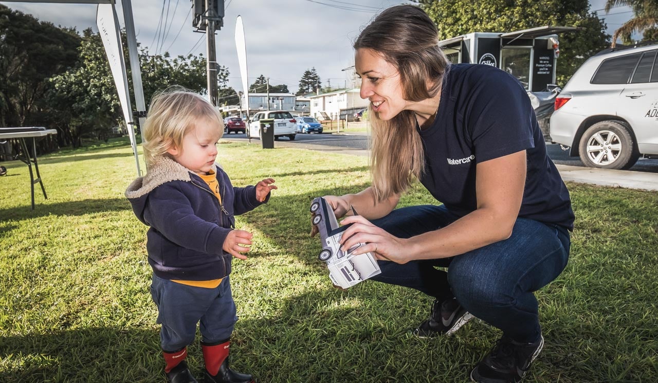 Stakeholder liaison advisor, Jennifer Charteris shares a toy truck and a moment, with a young resident at an infrastructure project information day.