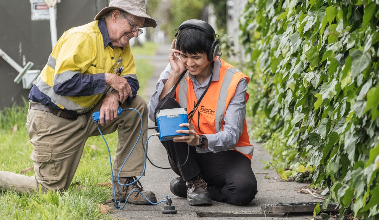 Watercare staff using audio equipment to sonically detect underground leaks.