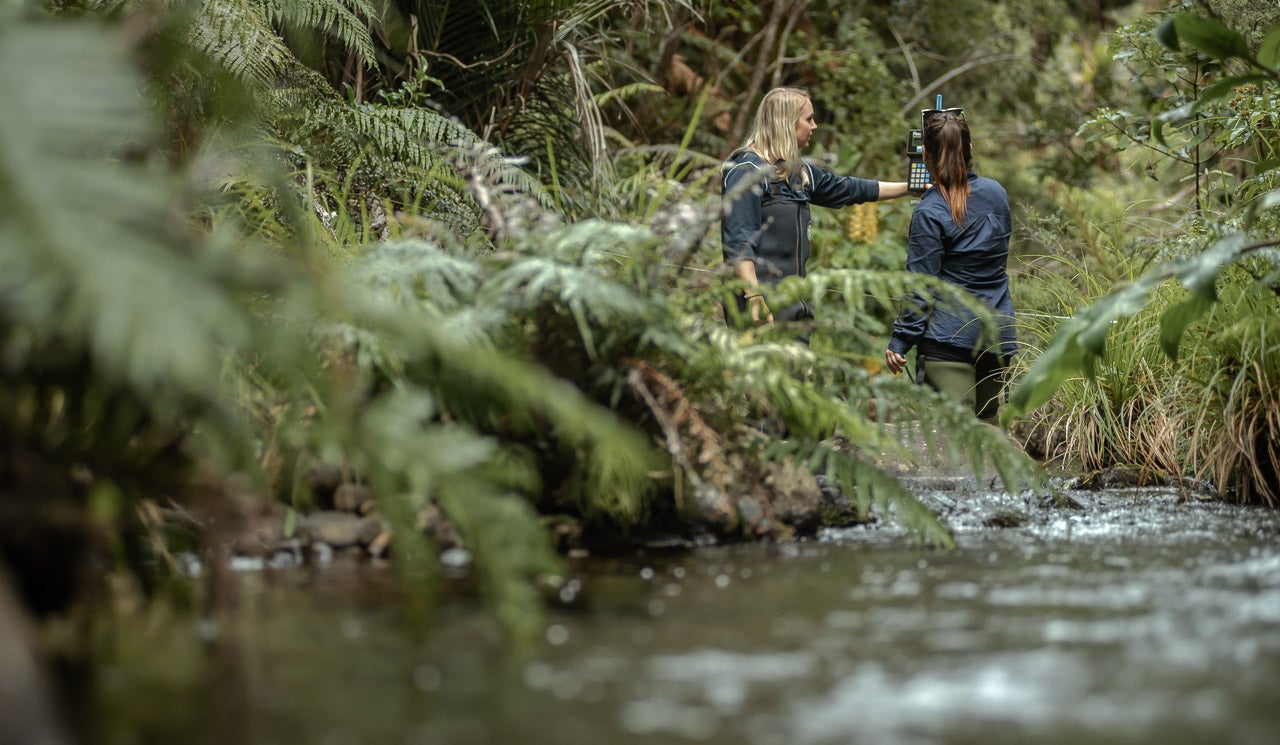 Watercare hydrologist Florence Mills and colleague take flow measurements in tributary stream in the Upper Huia dam.