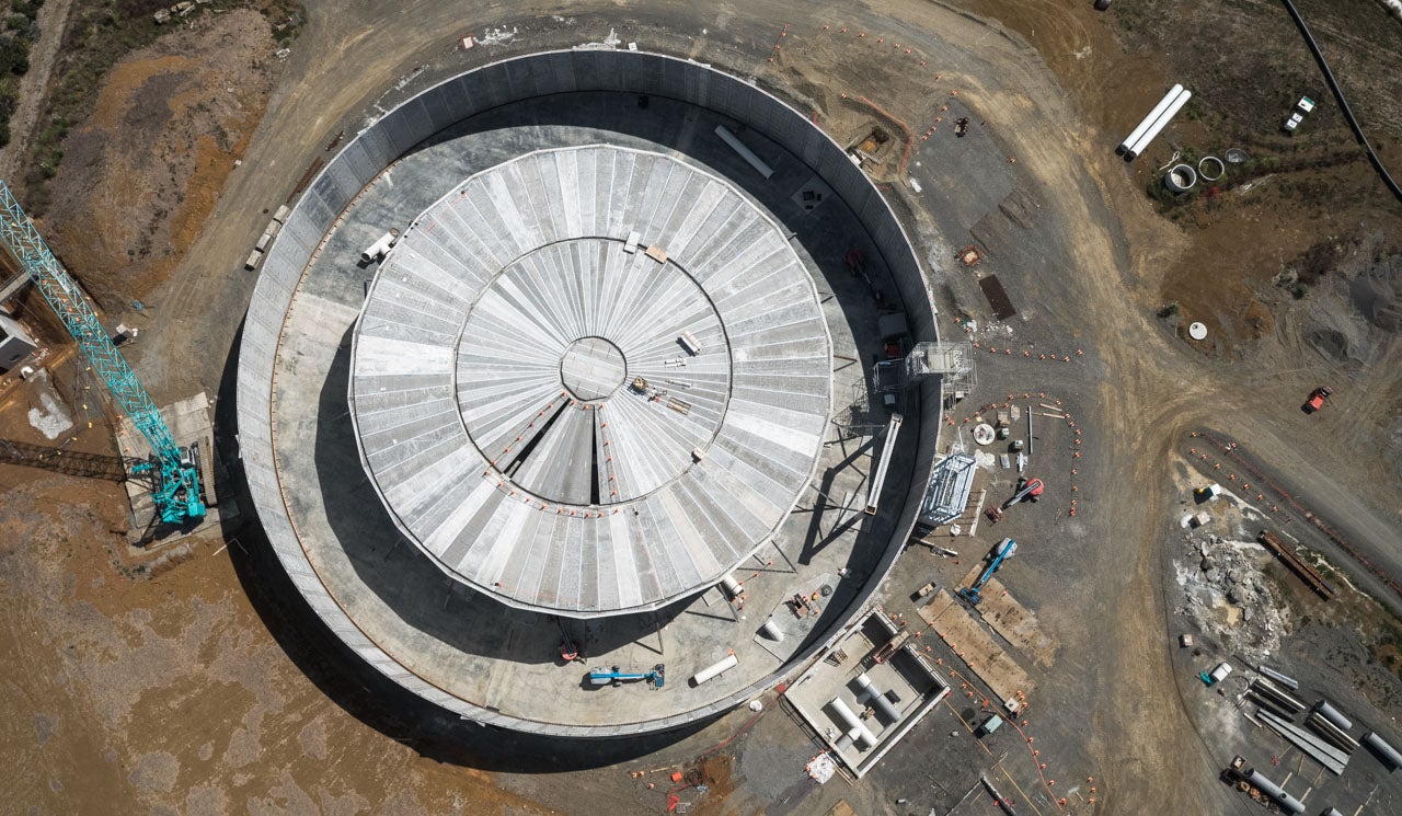 Pukekohe East Reservoir under construction, an aerial view showing the scale of the near complete works and the work site with crane.